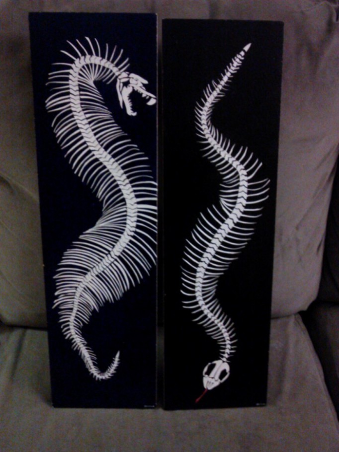 two snake skeletons created with paper decoupaged onto wood and acrylic