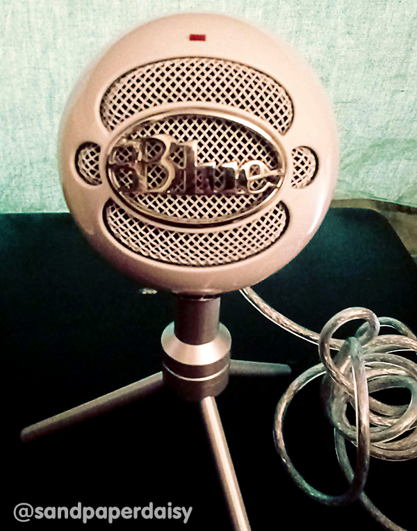 A photo of a Blue Snowball microphone, a ball shaped microphone mounted on a tripod used in podcasting and other endeavors